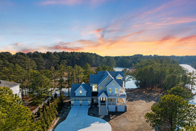 Inspiration for a large coastal white two-story mixed siding house exterior remodel in Other with a shingle roof and a gray roof