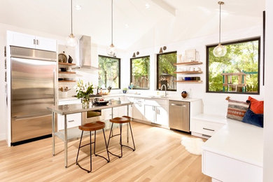 Kitchen - mid-sized contemporary l-shaped light wood floor and brown floor kitchen idea in Other with an undermount sink, shaker cabinets, quartz countertops, subway tile backsplash, stainless steel appliances, an island, white cabinets, white backsplash and white countertops
