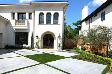 This is an example of a large transitional two-storey stucco white exterior in Houston with a flat roof.