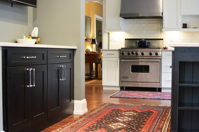 Inspiration for a large transitional l-shaped medium tone wood floor and brown floor eat-in kitchen remodel in New York with an undermount sink, shaker cabinets, dark wood cabinets, quartz countertops, white backsplash, porcelain backsplash, stainless steel appliances, an island and white countertops