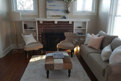 Example of a mid-sized classic formal and enclosed medium tone wood floor living room design in Other with beige walls, a standard fireplace, a brick fireplace and no tv