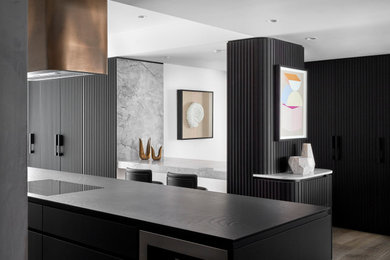This is an example of a large contemporary kitchen pantry in Melbourne with raised-panel cabinets, dark wood cabinets, quartz benchtops, marble splashback, medium hardwood floors and with island.