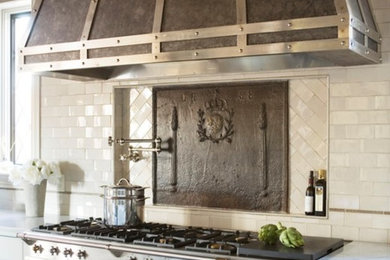 Large transitional l-shaped dark wood floor and brown floor kitchen photo in Other with a farmhouse sink, beaded inset cabinets, white cabinets, white backsplash, subway tile backsplash, stainless steel appliances, an island and white countertops
