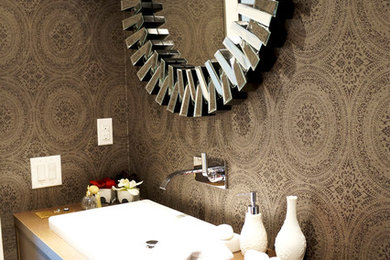 Inspiration for a mid-sized timeless medium tone wood floor powder room remodel in Toronto with flat-panel cabinets, medium tone wood cabinets, a two-piece toilet, beige walls, a drop-in sink and wood countertops