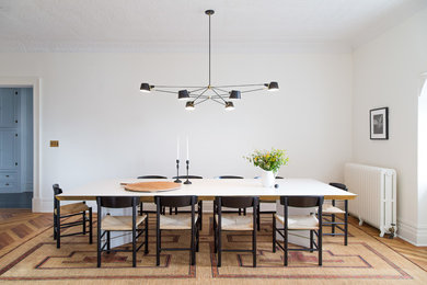 Inspiration for a victorian medium tone wood floor enclosed dining room remodel in New York with white walls