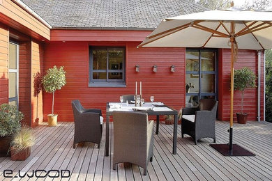 Idée de décoration pour une grande façade de maison rouge tradition en bois à un étage avec un toit à quatre pans.