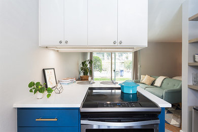 Example of a transitional ceramic tile kitchen design in Austin with shaker cabinets, white backsplash, glass tile backsplash, stainless steel appliances and an island