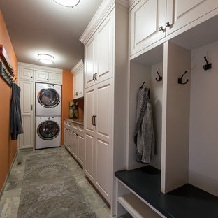 ミネアポリスの中サイズのトランジショナルスタイルのおしゃれな家事室 (アンダーカウンターシンク、落し込みパネル扉のキャビネット、白いキャビネット、御影石カウンター、オレンジの壁、スレートの床、上下配置の洗濯機・乾燥機) の写真