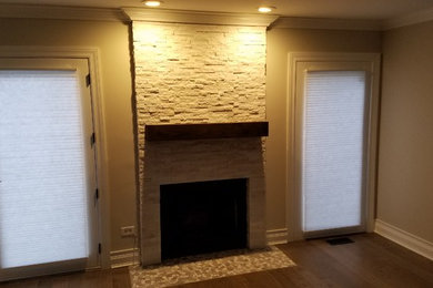 Photo of a large country open concept family room in Chicago with grey walls, medium hardwood floors, a standard fireplace and a stone fireplace surround.
