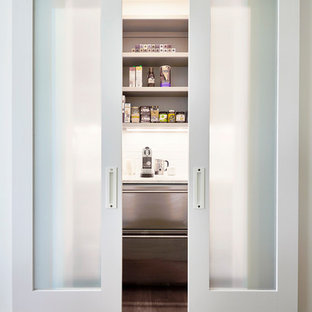 Réalisation d'une grande arrière-cuisine minimaliste en U avec un évier 2 bacs, un placard à porte vitrée, des portes de placard blanches, un plan de travail en stéatite, une crédence multicolore, une crédence en marbre, un électroménager en acier inoxydable, un sol en bois brun, un îlot central et un sol beige.