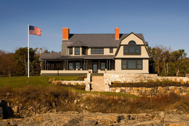 Example of a large classic beige two-story wood house exterior design in Portland Maine with a gambrel roof and a shingle roof