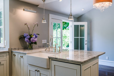 Mid-sized trendy u-shaped gray floor open concept kitchen photo in Boston with a farmhouse sink, raised-panel cabinets, white cabinets, quartz countertops, stainless steel appliances and white countertops