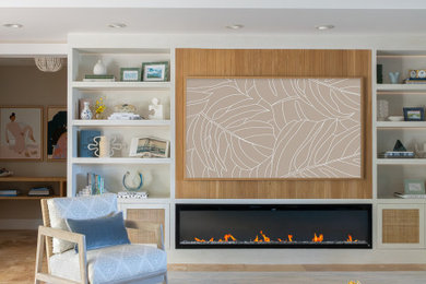 Living room - coastal living room idea in Hawaii with a hanging fireplace and a media wall