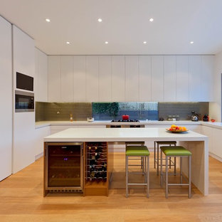 Design ideas for a contemporary l-shaped kitchen in Melbourne with an undermount sink, flat-panel cabinets, white cabinets, stainless steel appliances, medium hardwood floors and with island.