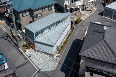 他の地域にあるお手頃価格の小さなモダンスタイルのおしゃれな家の外観 (混合材サイディング、下見板張り、長方形) の写真