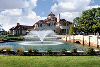 Example of a huge trendy beige three-story stone exterior home design in Dallas with a hip roof