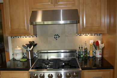 Eat-in kitchen - mid-sized traditional u-shaped eat-in kitchen idea in San Francisco with a single-bowl sink, raised-panel cabinets, medium tone wood cabinets, granite countertops, multicolored backsplash, mosaic tile backsplash and stainless steel appliances