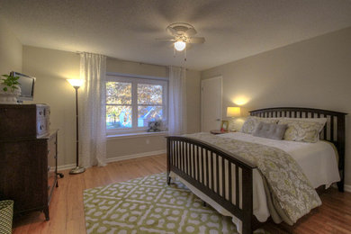 Mid-sized transitional guest bedroom in Kansas City with grey walls and light hardwood floors.