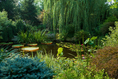 Photo of a large traditional full sun backyard water fountain landscape in New York for summer.