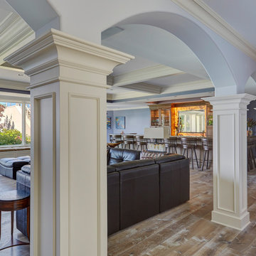 Paneled Columns Connect Multiple Arched Openings in Lower Level Family Room