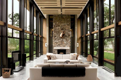 Inspiration for a large contemporary formal enclosed living room in Atlanta with beige walls, concrete floors, a standard fireplace, a stone fireplace surround and a freestanding tv.