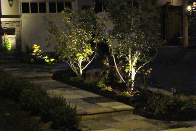 Design ideas for a mid-sized traditional front yard stone landscaping in Toronto.