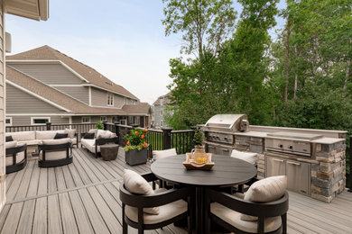 Diseño de terraza de estilo americano grande en patio trasero y anexo de casas con cocina exterior y barandilla de metal