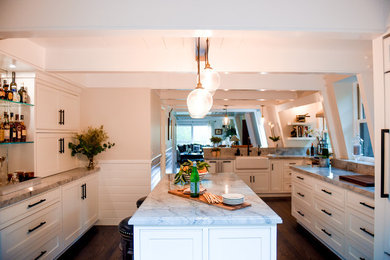 Eat-in kitchen - mid-sized transitional u-shaped dark wood floor, brown floor and exposed beam eat-in kitchen idea in San Francisco with a farmhouse sink, shaker cabinets, white cabinets, quartzite countertops, gray backsplash, subway tile backsplash, paneled appliances, an island and gray countertops