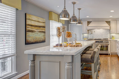 Example of a transitional medium tone wood floor kitchen design in Miami with a single-bowl sink, raised-panel cabinets, gray cabinets, marble countertops, gray backsplash, porcelain backsplash, stainless steel appliances and an island