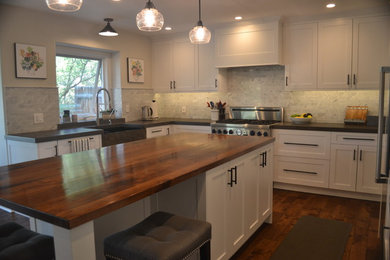 Design ideas for a mid-sized traditional u-shaped eat-in kitchen in Denver with a farmhouse sink, shaker cabinets, white cabinets, concrete benchtops, white splashback, subway tile splashback, stainless steel appliances, medium hardwood floors, with island, brown floor and brown benchtop.