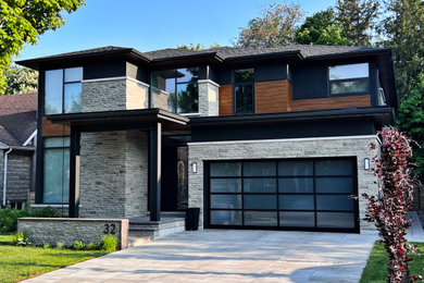 Example of a mid-sized minimalist gray two-story stone house exterior design with a shingle roof and a black roof