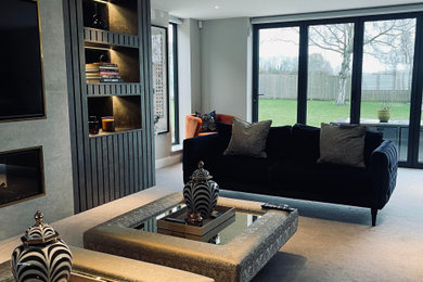 Inspiration for a large contemporary formal enclosed living room in Kent with brown walls, carpet, a hanging fireplace and a built-in media unit.