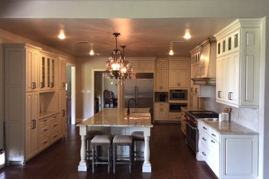 Elegant dark wood floor eat-in kitchen photo in Austin with raised-panel cabinets, white cabinets, granite countertops, white backsplash, ceramic backsplash, stainless steel appliances and an island