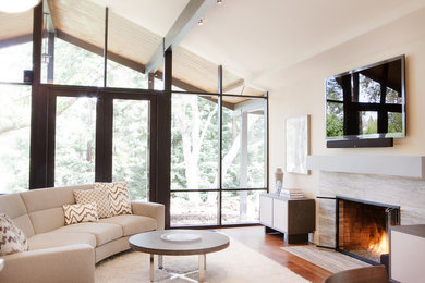 Inspiration for a mid-sized contemporary open concept medium tone wood floor and brown floor living room remodel in San Francisco with beige walls, a standard fireplace and a wall-mounted tv