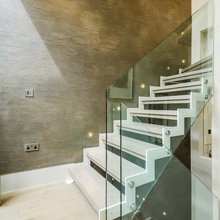Photo of a contemporary wood u-shaped glass railing staircase in London with open risers.