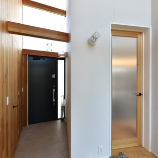 他の地域の片開きドアアジアンスタイルのおしゃれな玄関 (白い壁、黒いドア、グレーの床) の写真