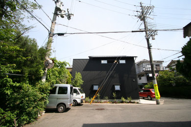 Foto de fachada de casa negra y gris de estilo zen pequeña de dos plantas con revestimiento de metal, tejado a dos aguas, tejado de metal y panel y listón