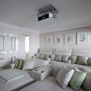 Idée de décoration pour une salle de cinéma tradition fermée et de taille moyenne avec un mur beige et un écran de projection.