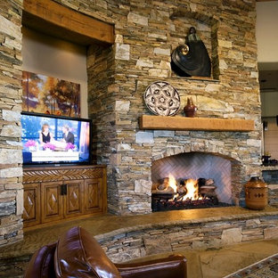 Modelo de salón abierto, mediterráneo, grande, con paredes beige, suelo de pizarra, chimenea tradicional, marco de chimenea de piedra, pared multimedia y suelo beige