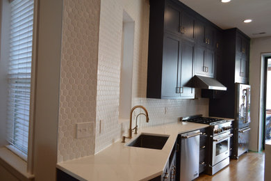 Mid-sized trendy galley light wood floor and brown floor eat-in kitchen photo in DC Metro with an undermount sink, shaker cabinets, blue cabinets, quartz countertops, white backsplash, ceramic backsplash, stainless steel appliances, an island and white countertops