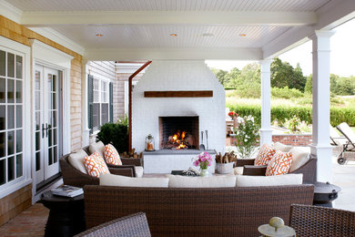 Inspiration for a mid-sized beach style backyard patio in Boston with a fire feature, brick pavers and a roof extension.