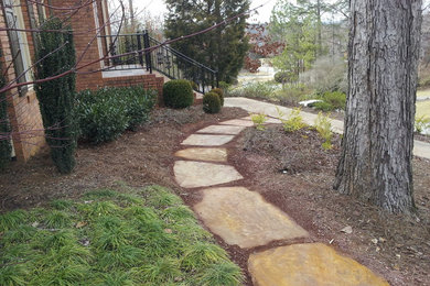 Photo of a mid-sized backyard partial sun garden for spring in Birmingham with a garden path and natural stone pavers.