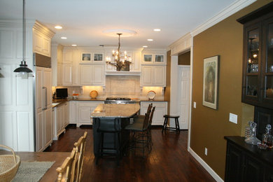 Eat-in kitchen - traditional l-shaped eat-in kitchen idea in Cincinnati with an undermount sink, raised-panel cabinets, distressed cabinets, black backsplash, subway tile backsplash and colored appliances