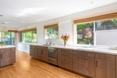 Kitchen - modern kitchen idea in Sacramento with an undermount sink, flat-panel cabinets, medium tone wood cabinets, quartzite countertops, white backsplash, porcelain backsplash and white countertops