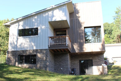 Inspiration for a mid-sized contemporary white two-story wood flat roof remodel in Other