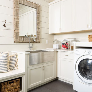 Medium sized country l-shaped utility room in Atlanta with a belfast sink, recessed-panel cabinets, white cabinets, white walls, grey floors, white worktops, engineered stone countertops, concrete flooring and a side by side washer and dryer.