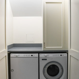 Expansive classic single-wall laundry cupboard in Cleveland with white walls, carpet, a side by side washer and dryer and multi-coloured floors.