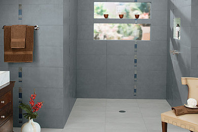 Example of a mid-sized gray tile and ceramic tile bathroom design in Charlotte with recessed-panel cabinets