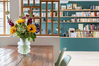 Cette photo montre une salle à manger ouverte sur le salon moderne de taille moyenne avec un mur vert et parquet clair.