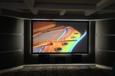 Imagen de cine en casa cerrado tradicional de tamaño medio con paredes grises, moqueta y pantalla de proyección